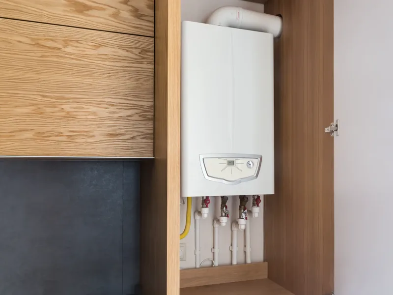 Modern combi boiler installed in a kitchen cupboard