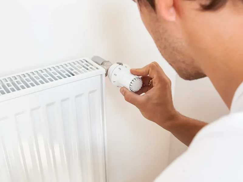 Adjusting a thermostatic radiator valve on a central heating radiator